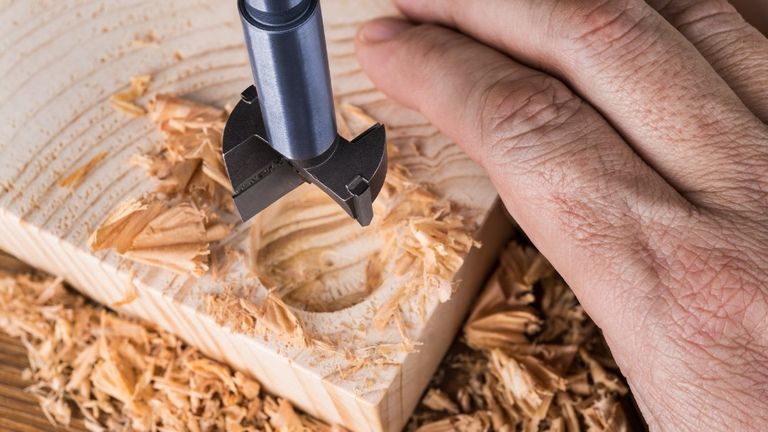 hombre realizando corte en madera